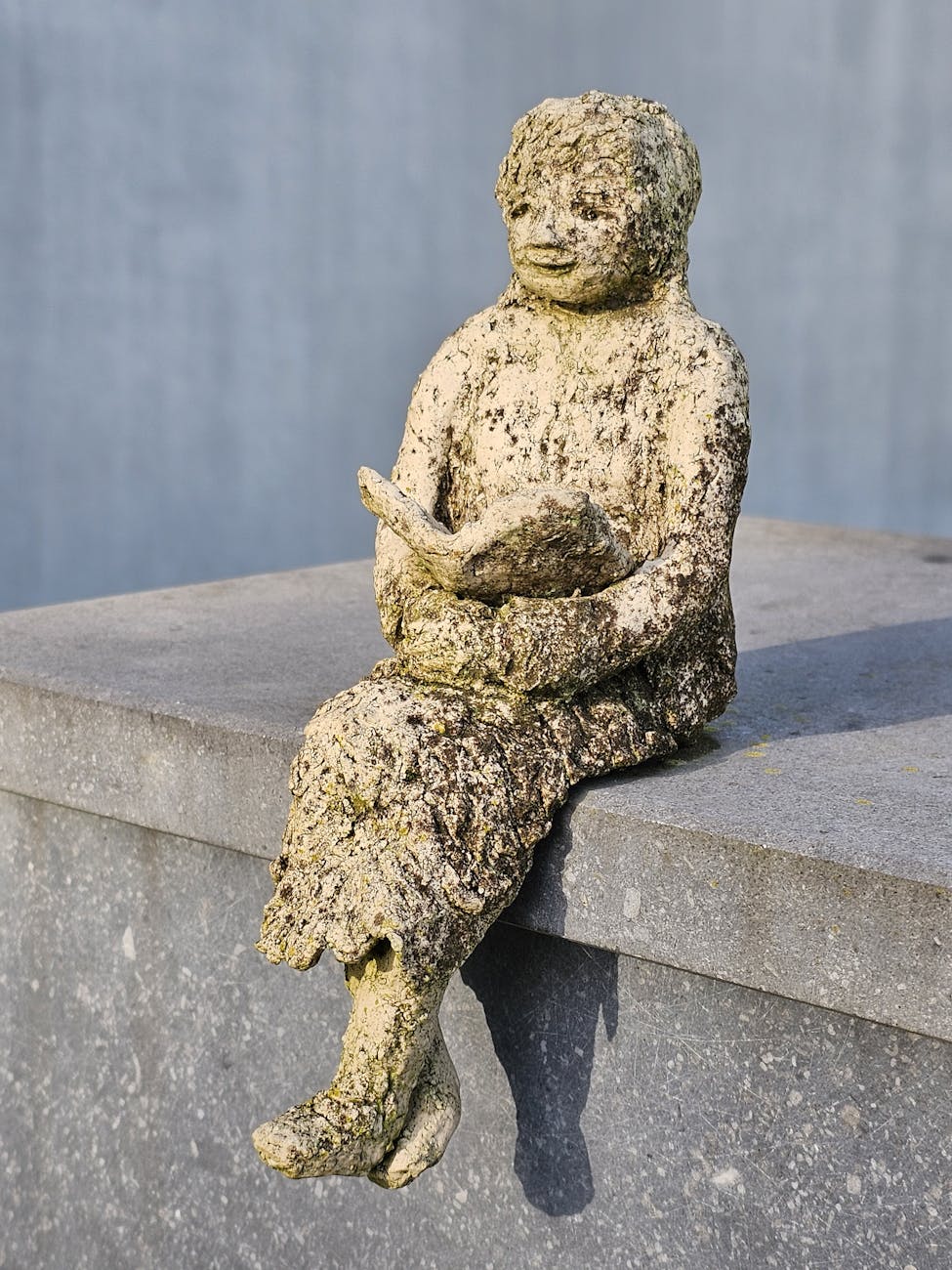 Ancient stone sculpture of a female reading an open book